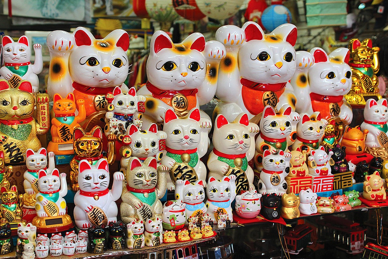 Maneki Neko figurines in diverse colors, sizes, and designs, showcasing the variety of the traditional Japanese lucky cat statues. Photo by Emanuel Golabiewski from Pixabay.